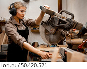 female carpenter using electric saw studio. Стоковое фото, агентство Ingram Publishing / Фотобанк Лори