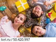 high angle view friends lying wooden floor surrounding by gift balloon confetti. Стоковое фото, агентство Ingram Publishing / Фотобанк Лори