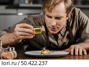 mid shot chef plating dish with olive oil. Стоковое фото, агентство Ingram Publishing / Фотобанк Лори