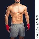 Portrait of a young male Body Combat atlhlete, isolated over a dark background. Стоковое фото, агентство Ingram Publishing / Фотобанк Лори