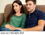 Young couple sitting on the sofa and dating. Стоковое фото, агентство Ingram Publishing / Фотобанк Лори