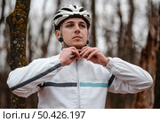 front view man putting safety helmet biking. Стоковое фото, агентство Ingram Publishing / Фотобанк Лори