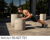 side view shirtless man doing push ups outdoors. Стоковое фото, агентство Ingram Publishing / Фотобанк Лори