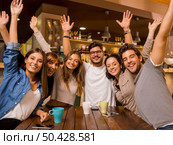 Group of friends raising hands and looking to the camera . Стоковое фото, агентство Ingram Publishing / Фотобанк Лори
