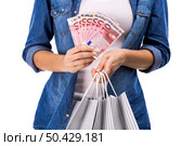 Beauitful woman holding shopping bags and some Euro currency notes, isolated over white background. Woman with money and shopping bags. Стоковое фото, агентство Ingram Publishing / Фотобанк Лори