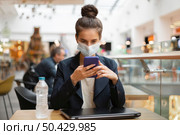 businesswoman with medical mask checking her phone. Стоковое фото, агентство Ingram Publishing / Фотобанк Лори