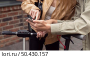 couple with electric scooters smartphone outdoors. Стоковое фото, агентство Ingram Publishing / Фотобанк Лори