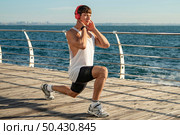 man listening music beach while training. Стоковое фото, агентство Ingram Publishing / Фотобанк Лори
