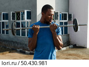 medium shot man lifting weight. Стоковое фото, агентство Ingram Publishing / Фотобанк Лори