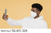 portrait stylish man with face mask taking selfie. Стоковое фото, агентство Ingram Publishing / Фотобанк Лори