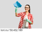 Pretty woman wearing gloves, using a cleaning spray and cleaning the house. Стоковое фото, агентство Ingram Publishing / Фотобанк Лори