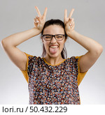 Funny portrait of woman making rabbit ears. Стоковое фото, агентство Ingram Publishing / Фотобанк Лори