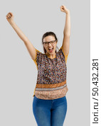 Beautiful and happy woman with both arms up, isolated over a gray background . Стоковое фото, агентство Ingram Publishing / Фотобанк Лори
