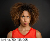 Portrait of a beautiful African American woman with a suspicious expression. Стоковое фото, агентство Ingram Publishing / Фотобанк Лори