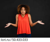 Beautiful African American woman with arms open against a black background. Стоковое фото, агентство Ingram Publishing / Фотобанк Лори