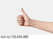 Female hand making thumb up gesture approval or voting sign isolated on white background.. Thumb up female gesturing hand on white. Стоковое фото, агентство Ingram Publishing / Фотобанк Лори