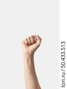 Female hand clenched fist raised up in victory, isolated on a white background.. Fist up, victory symbol female hand. Стоковое фото, агентство Ingram Publishing / Фотобанк Лори