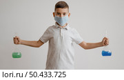 boy with medical mask holding chemical elements recipients. Стоковое фото, агентство Ingram Publishing / Фотобанк Лори