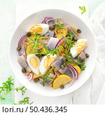 Herring and boiled potato salad with egg, capers and red onion. Top view. Стоковое фото, агентство Ingram Publishing / Фотобанк Лори