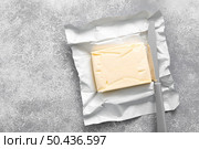 Block of butter with butter knife in a open pack. Стоковое фото, агентство Ingram Publishing / Фотобанк Лори