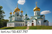 A majestic white Orthodox church with golden domes stands in a park with colorful autumn trees under a blue sky with clouds. Стоковое AI-видео, аниматор Sergey Grishin / Фотобанк Лори