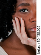 fair skinned woman s hand touching african female friend s chin. Стоковое фото, агентство Ingram Publishing / Фотобанк Лори