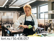 female chef removing apple skin. Стоковое фото, агентство Ingram Publishing / Фотобанк Лори
