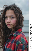 Closeup shot of pretty teenage girl with long dark curly hair wearing casual cozy plaid shirt, staying alone, thinking, dreaming, watching at camera, catching wind in her haircut. Стоковое AI-видео, аниматор Sergey Grishin / Фотобанк Лори
