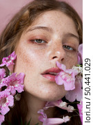 freckled woman holding pink flower. Стоковое фото, агентство Ingram Publishing / Фотобанк Лори