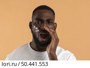 man screaming holding hand his mouth. Стоковое фото, агентство Ingram Publishing / Фотобанк Лори