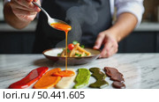 A chef's hand holding a spoon dripping with colorful sauces sriracha, tahini, chimichurri arranged in a rainbow pattern on a marble surface. Стоковое AI-видео, аниматор Sergey Grishin / Фотобанк Лори