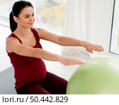 young woman exercising with fitness ball while being pregnant. Стоковое фото, агентство Ingram Publishing / Фотобанк Лори