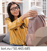 female vlogger home unboxing clothes. Стоковое фото, агентство Ingram Publishing / Фотобанк Лори