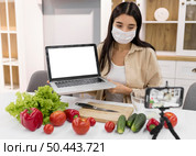 female vlogging home with vegetables laptop. Стоковое фото, агентство Ingram Publishing / Фотобанк Лори