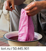 man soaking cloth natural pigment. Стоковое фото, агентство Ingram Publishing / Фотобанк Лори