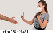 woman with face mask refusing hand shake. Стоковое фото, агентство Ingram Publishing / Фотобанк Лори