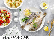 Dorada fish sea bream baked, fresh vegetable greek salad, boiled potatoes with garlic and olives and tzatziki dip. Healthy food. Mediterranean diet. Стоковое фото, агентство Ingram Publishing / Фотобанк Лори