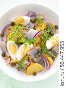 Herring and boiled potato salad with egg, capers and red onion. Top view. Стоковое фото, агентство Ingram Publishing / Фотобанк Лори