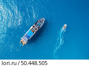 Aerial view of beautiful yacht and boat on the sea at sunset in summer. Lefkada island, Greece. Top view of luxury yachts,motorboat, clear blue water. Travel. Cruise vacation. Yachting. Seascape. Стоковое фото, агентство Ingram Publishing / Фотобанк Лори