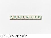 Feminism word formed of scrabble blocks on white background. Creative template with awareness concept.. Feminism formed of scrabble blocks on white background. Стоковое фото, агентство Ingram Publishing / Фотобанк Лори