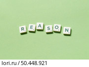 Reason word formed of scrabble tiles on green background. Creative business postcard idea in pastel palette.. Reason formed of scrabble tiles on green background. Стоковое фото, агентство Ingram Publishing / Фотобанк Лори