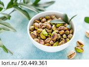 Pistachios. Whole pistachios with green leaves and pistachio nut kernels. Healthy natural vegetarian organic food. Top view, copy space. Стоковое фото, агентство Ingram Publishing / Фотобанк Лори