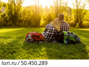 Young couple with backpacks sitting on the grass. Стоковое фото, агентство Ingram Publishing / Фотобанк Лори