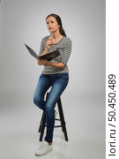 Beautiful woman sitting on a bench holding a folder and thinking. Стоковое фото, агентство Ingram Publishing / Фотобанк Лори