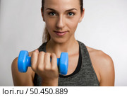 Young fitness woman making exercises with dumbbells. Стоковое фото, агентство Ingram Publishing / Фотобанк Лори