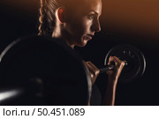 Shot of a beautiful young woman in a workout gear lifting weights. Стоковое фото, агентство Ingram Publishing / Фотобанк Лори