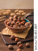 Hazelnuts in a ceramic bowl on a rustic kitchen countertop. Стоковое фото, агентство Ingram Publishing / Фотобанк Лори