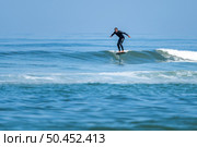 A middle aged man doing some foil surfing or hydrofoil surfing in the sea on a bright sunny day. Стоковое фото, агентство Ingram Publishing / Фотобанк Лори