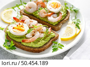 Toast with shrimps, avocado guacomole, arugula and boiled egg. Стоковое фото, агентство Ingram Publishing / Фотобанк Лори