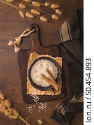 Basmati rice in ceramic bowl with wooden scoop on rustic countertop. Стоковое фото, агентство Ingram Publishing / Фотобанк Лори